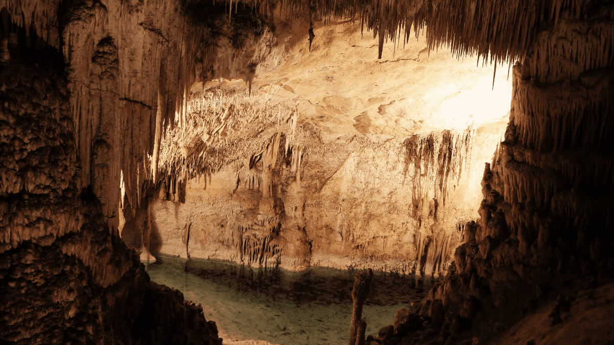 Estalactites sobre lago cristalino em caverna no Vietnã