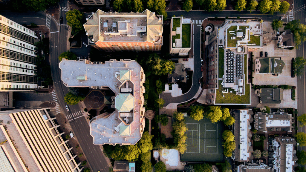 Vista aérea de conjunto urbano com edifícios e quadras simetricamente alinhados, incluindo quadra esportiva e telhados verdes.