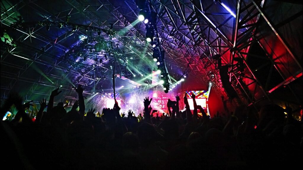 Multidão em show noturno com luzes de palco intensas
