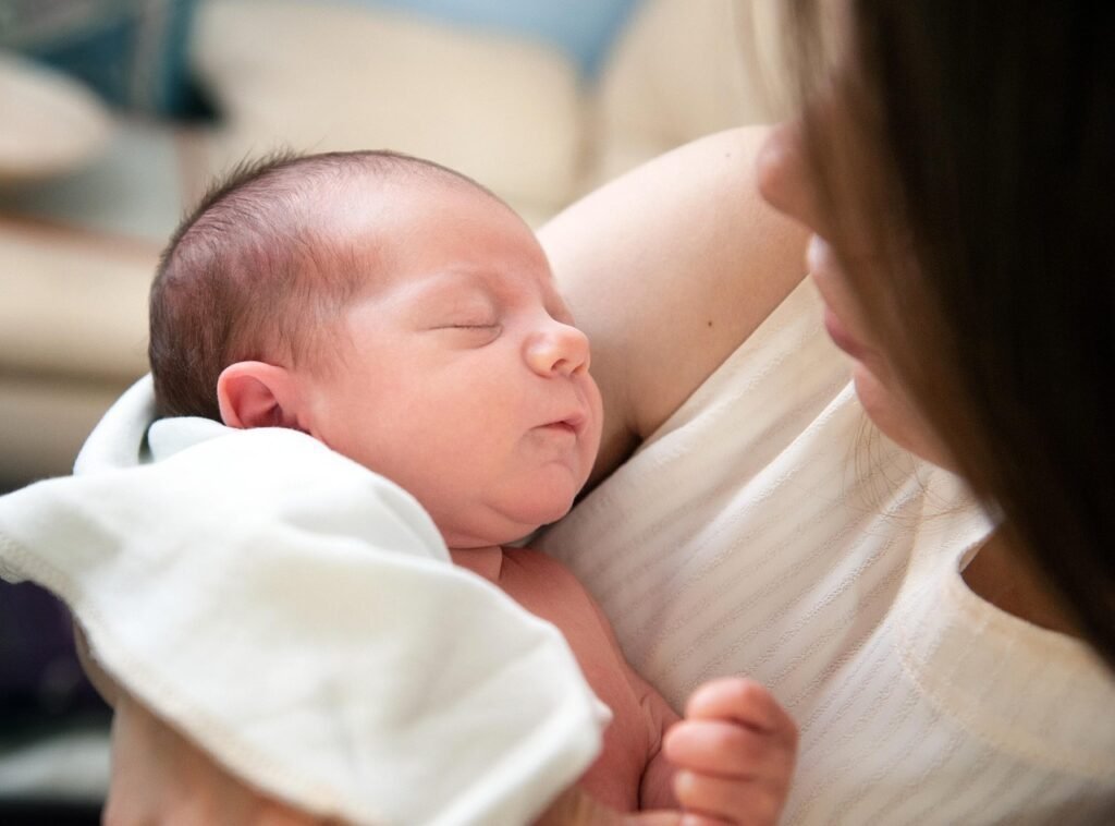 Mãe olhando com amor para seu bebê recém-nascido